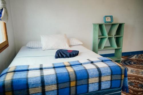 a bedroom with a bed with a blue and white blanket at Casa Madera in San Marcos La Laguna