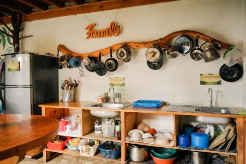 a kitchen with pots and pans hanging on the wall at Casa Madera in San Marcos La Laguna