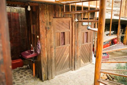 a bathroom with a wooden door and a sink at Casa Madera in San Marcos La Laguna
