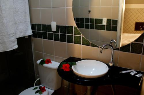 a bathroom with a toilet and a sink and a mirror at Hotel & Motel Henrique Dias (Adults Only) in Recife