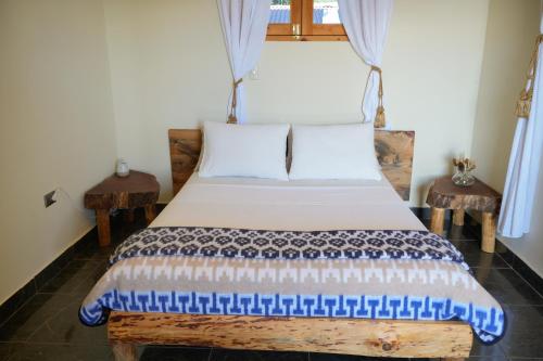a bedroom with a bed with blue and white sheets at Casa Madera in San Marcos La Laguna