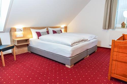 a bedroom with a bed and a red carpet at Simon´s Ferienwohnungen in Kurort Oberwiesenthal