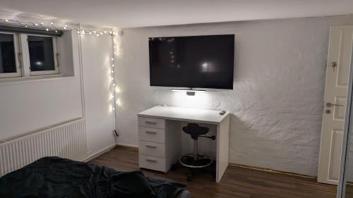 a bedroom with a tv on a wall with a desk at Sleep In Lynge in Lynge