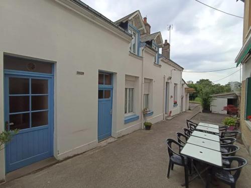 une rangée de tables et de chaises à côté d'un bâtiment dans l'établissement Le bouf tard chambre vue sur jardin CH7, à Vendôme