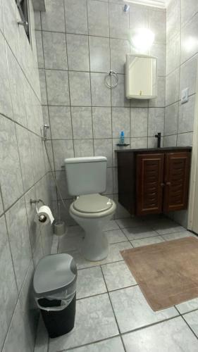 a bathroom with a toilet and a trash can at Apartamento Matteo in Ubatuba