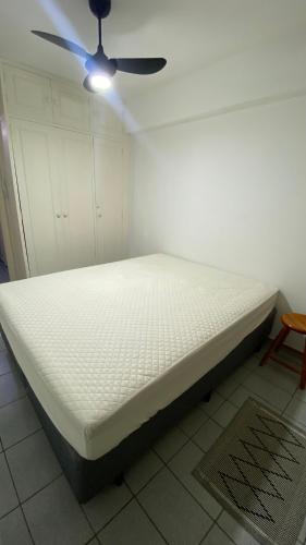 a bed in a room with a ceiling fan at Apartamento Matteo in Ubatuba