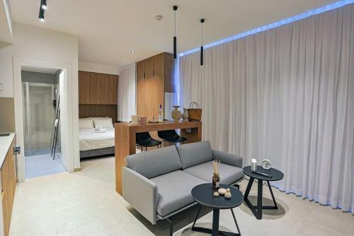 1 dormitorio y sala de estar con sofá y mesas. en Luxury Studio Beach Flat 527, en Tel Aviv