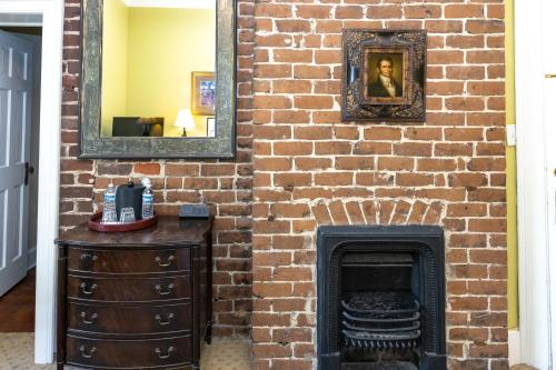 a brick wall with a fireplace and a mirror at Eliza Thompson House, Historic Inns of Savannah Collection in Savannah