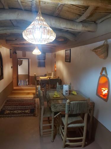 a dining room with a table and chairs and a chandelier at DAR DANI café restaurant in Boumalne
