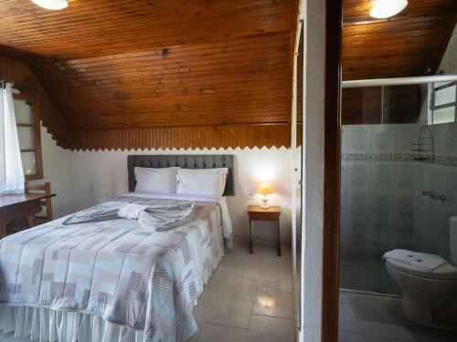 una camera con letto e un bagno con doccia di Pousada Natureza da Terra a Monte Verde