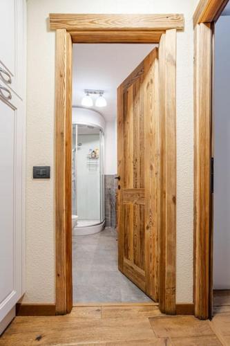 a hallway with a wooden door in a bathroom at Cervino View, Ski-In and WiFi! in Breuil-Cervinia