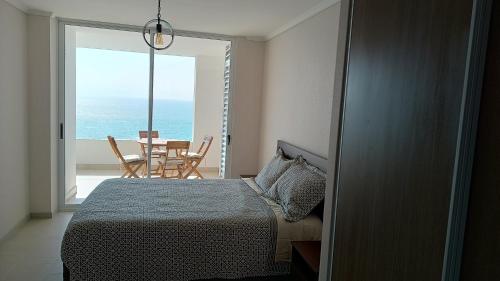 アリカにあるFrente a la mejor playa de Aricaのベッドがあり海が見える寝室