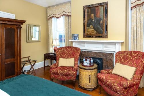 a bedroom with a fireplace and two chairs and a bed at Eliza Thompson House, Historic Inns of Savannah Collection in Savannah