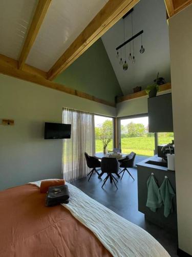 a bedroom with a large bed and a dining room at Het Bruineveld in Daarle