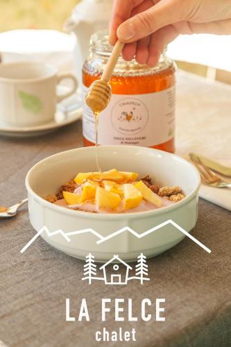 a person is stirring a bowl of food with a spoon at Chalet La Felce in Carisolo