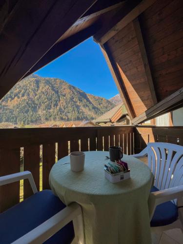 a table and chairs on a balcony with a view of a mountain at Chalet La Felce in Carisolo