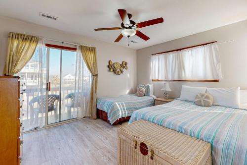 a bedroom with two beds and a ceiling fan at OIB28 Summer Sands in Ocean Isle Beach