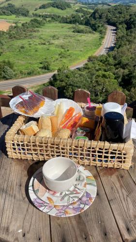 a basket of bread and a plate of food on a table at Chacrinha pousada e restaurante in Caldas