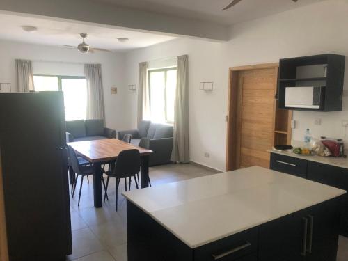 a kitchen and living room with a table and a dining room at Canonniers Luxury Stay in Pointe aux Cannoniers