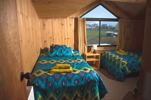 a bedroom with two beds in a room with a window at Hosta Altos de Gamboa in Castro