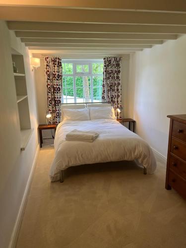a bedroom with a large bed and a window at The Exclusive 6 bedroom Farm House, Markington incl heated pool and The Richmond Hill one bedroom Cottage in Ingerthorpe