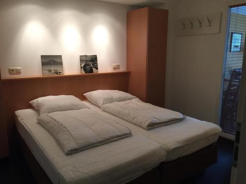 Un pat sau paturi într-o cameră la Amelander Kaap Appartement 112