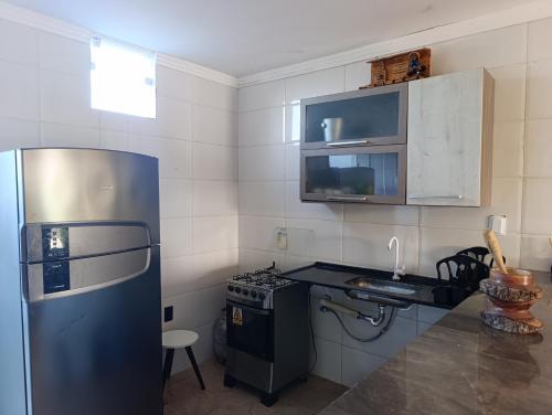 a small kitchen with a refrigerator and a stove at Casa lagoa dos tambaquis in Estância