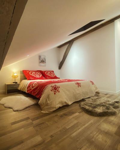 a bedroom with a large bed with red pillows at Gîtes les cocons des guédons LE MÉLÈZE in Le Ménil