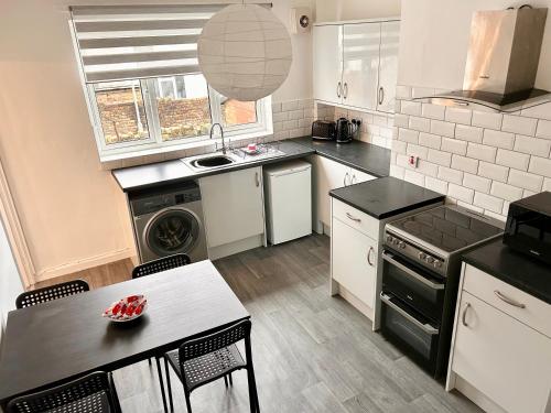 una cucina con lavello e fornello forno superiore di Egremont Home - Explore the Fells - Work Nearby a Woodend