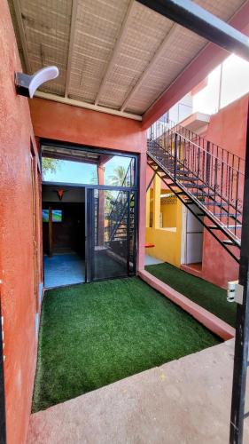 an outside view of a building with a staircase and grass at Casa Rosa in Sayulita