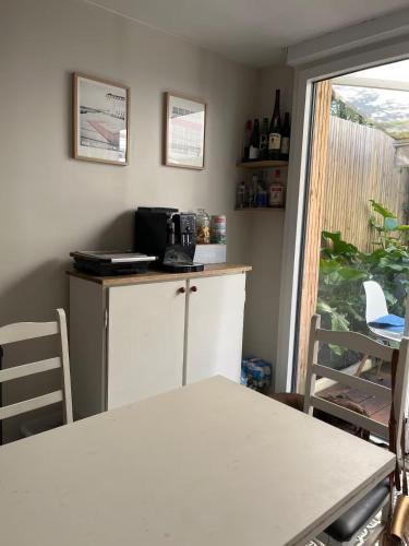 a kitchen with a counter and a table and a window at Maison COZY d'Anne So in Wimereux