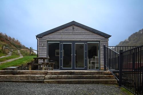 a small cabin with a glass door and some stairs at The Lodge in Llangollen