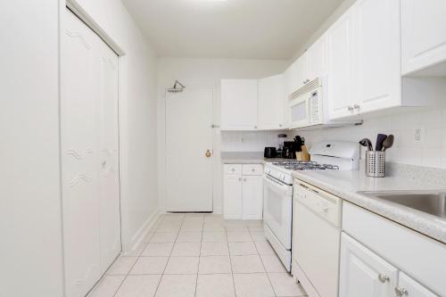 a white kitchen with white cabinets and white appliances at Spacious Apartment Perfect to Leisure and Business in Arlington