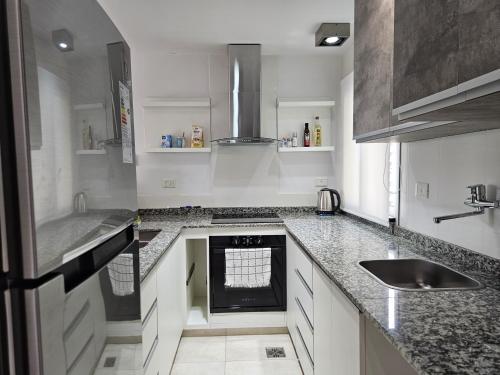 a kitchen with granite counter tops and a sink at Departamento de Lujo sobre Costanera in Posadas