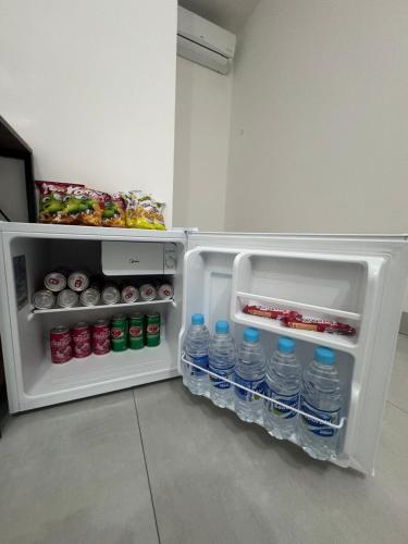 an open refrigerator with bottles of water in it at Pousada Parque do Lago in Sinop