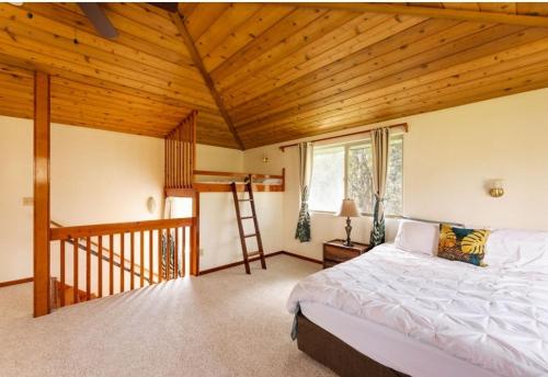 a bedroom with a bed and a wooden ceiling at Caldera- Hale Kumu La'au at Volcano in Volcano