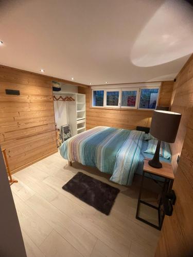 1 dormitorio con 1 cama y escritorio con lámpara en T'Choupette des Vosges, en La Bresse