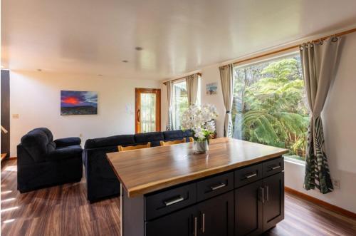 a living room with a couch and a table at Caldera- Hale Kumu La'au at Volcano in Volcano