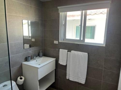 a bathroom with a white sink and a window at Penthouse Moderno, playa privada in Punta Cana