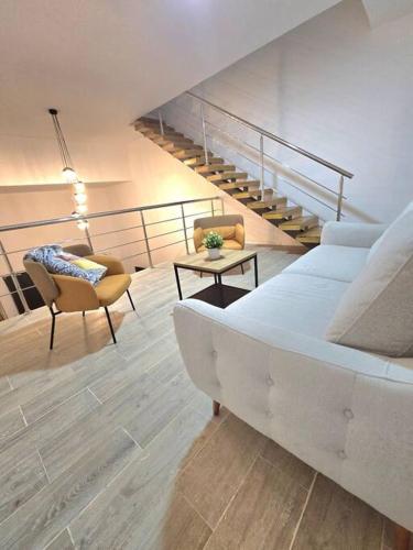 a living room with a bed and a staircase at Penthouse Moderno, playa privada in Punta Cana