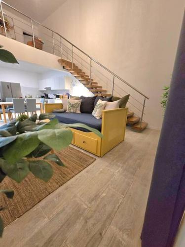 a living room with a blue couch and stairs at Penthouse Moderno, playa privada in Punta Cana