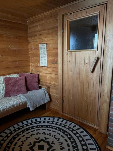 a room with a bed in a wooden cabin at Traditional lakeside cottage in Rovaniemi