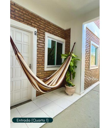 a hammock in front of a house at Condomínio Chalés Santo Antônio - Flecheiras in Trairi