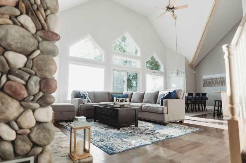 a living room with a couch and a stone wall at Large home on the Lake, Hot tub, Families, Groups in Central Lake