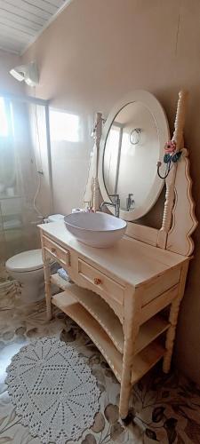 a bathroom with a sink and a mirror on a table at Hotel Dom Paulo in Lapa