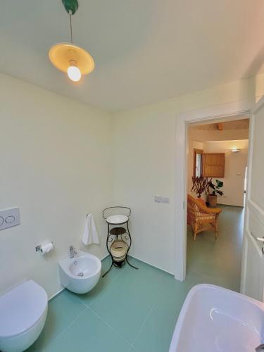 a white bathroom with two sinks and a toilet at Trulli Milena in Putignano