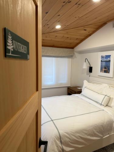 a bedroom with a bed and a wooden ceiling at Haliburton Post House in Minden