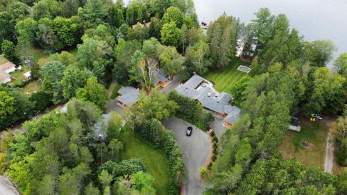 an aerial view of a house in the woods next to the water at Haliburton Post House in Minden