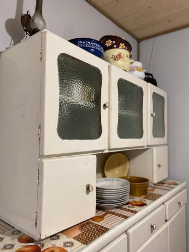 a white cabinet with dishes on top of it at Dom Na Wsi ,, Koszelówka " in Koszele