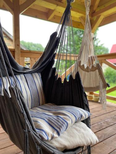 a hammock on a deck with a porch at Dom Na Wsi ,, Koszelówka " in Koszele